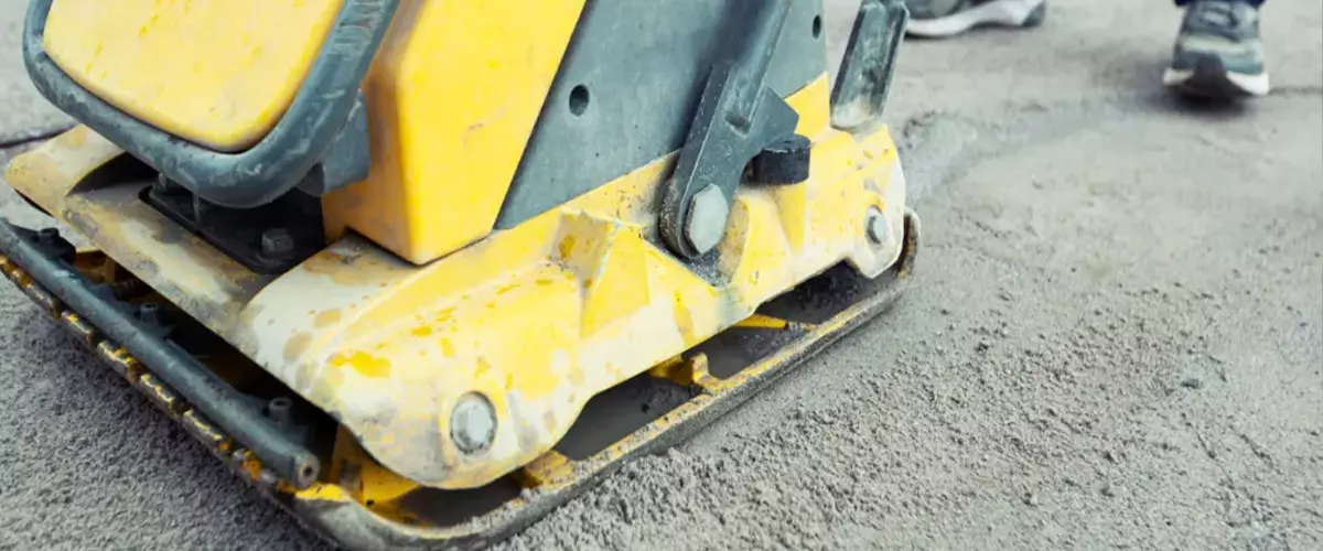 Tamping gravel using a vibration plate machine