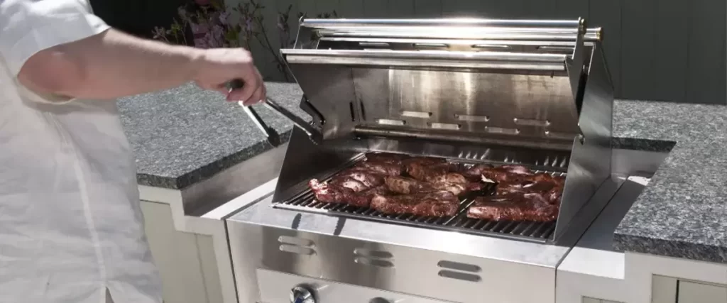Man using grill outdoor kitchen - Farrell’s Lawn And Garden Center