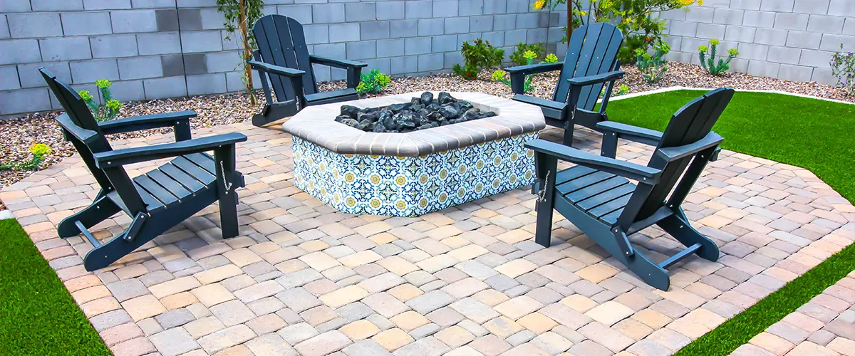 A paver patio in Bryan with a fireplace and plastic chairs