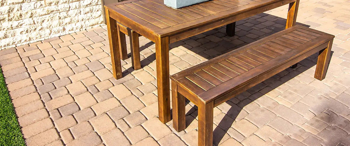 A paver patio with outdoor furniture made of wood