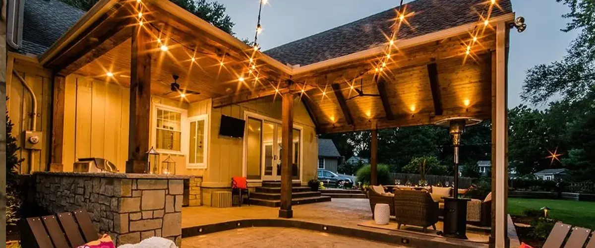 String lights and down lighting over an outdoor living space