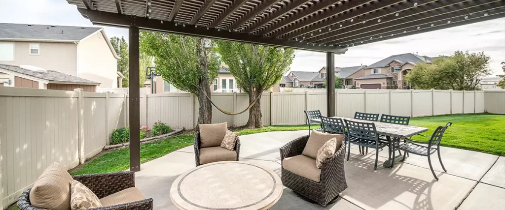 Woven armchairs with cushion and dining table under the pergola roof