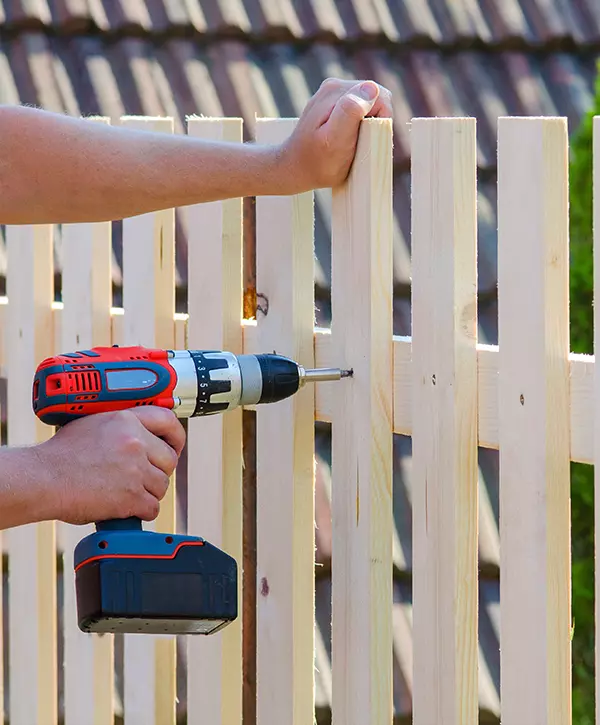 Man with Drill Installing Wood Fence In Whitehouse Ohio