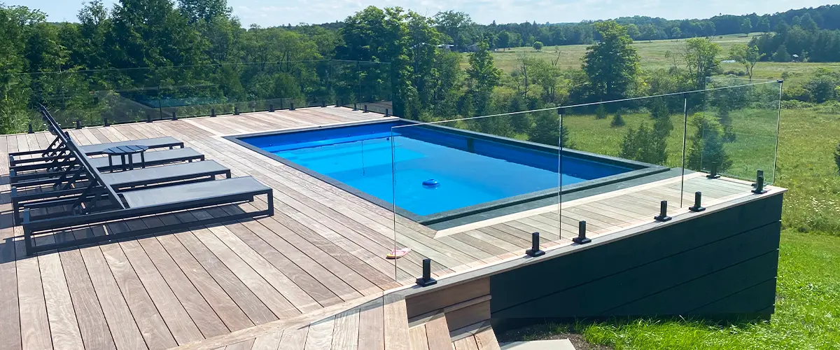 Rectangular in-ground swimming pool installed in Toldeo, with modern landscaping and lounge chairs.