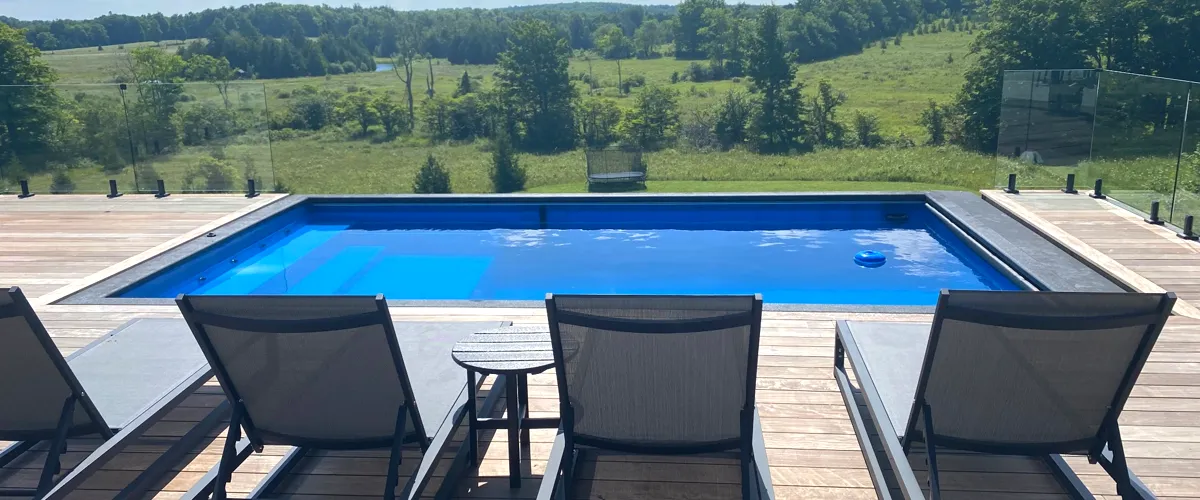 Poolside chairs facing a scenic countryside view, perfect for relaxation